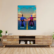 Personalized couple canvas of two people holding hands on motorcycles at sunset, with custom lyrics shaped into a heart above the open road and their names displayed at the bottom — LOVECOUPLET