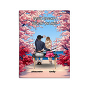 Personalized couple canvas of two people sitting together on a bench beneath blooming pink spring flowers, with a custom romantic quote above them and their names displayed at the bottom — LOVECOUPLET