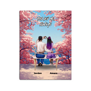 Personalized couple canvas of two people sitting together on a bench beneath blooming pink spring flowers, with a custom romantic quote above them and their names displayed at the bottom — LOVECOUPLET