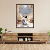 Personalized wedding couple framed canvas of a bride and groom sitting on a bench beneath a blooming floral garden arch, with custom lyrics shaped into a heart above them and their names at the base of the scene — LOVECOUPLET