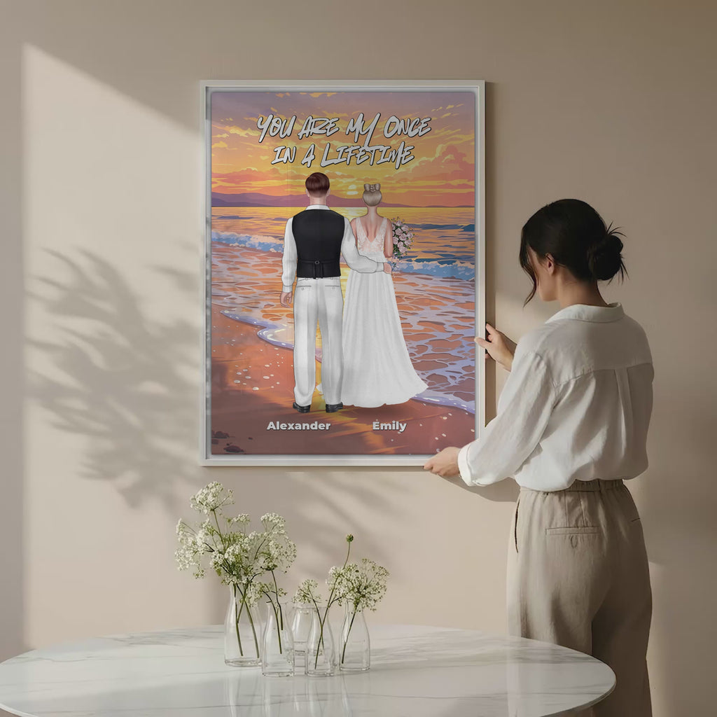 Once in a Lifetime personalized wedding couple canvas of two people standing together on a golden beach at sunset, with a custom romantic quote above them, names displayed at the bottom, and personalized wedding characters — LOVECOUPLET