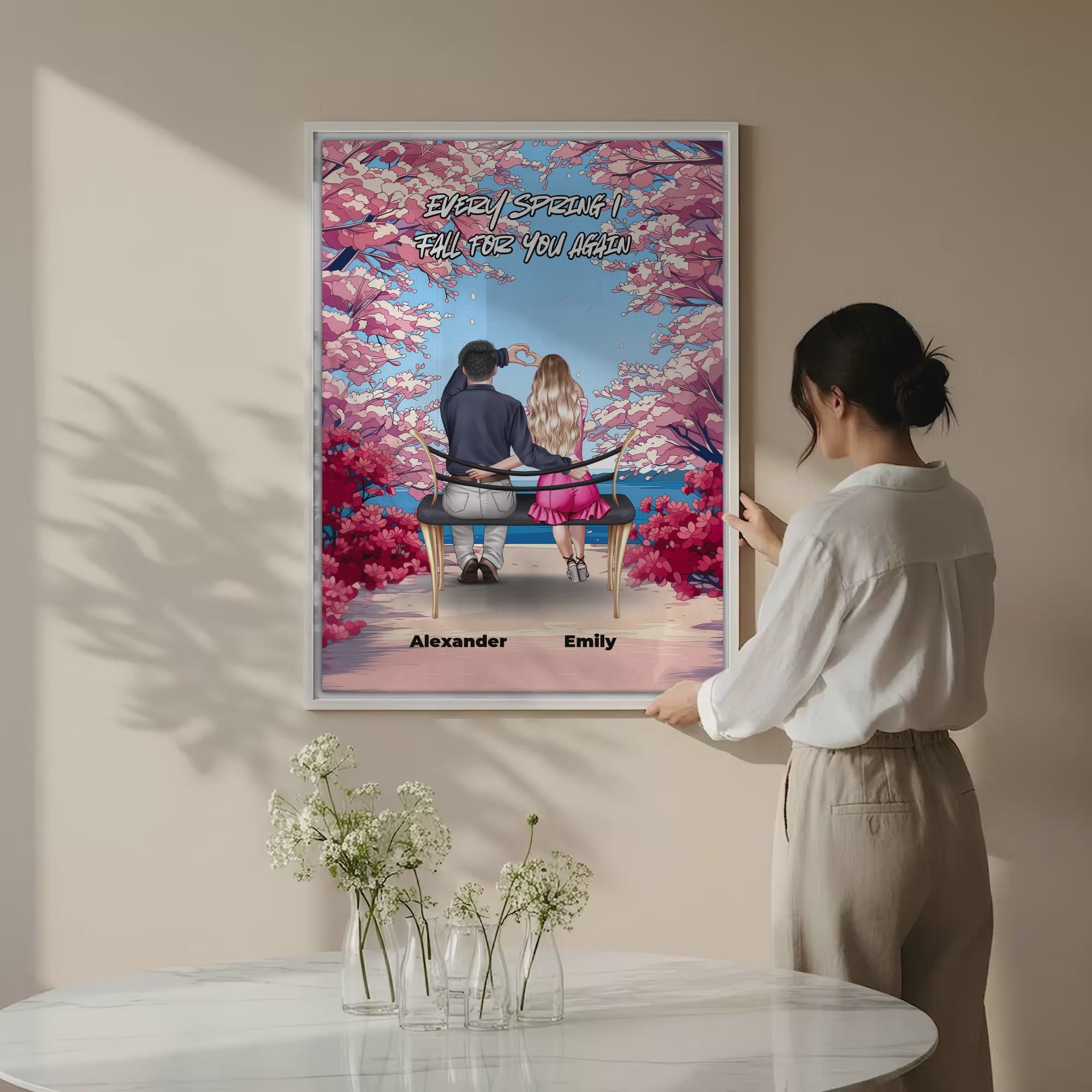 Personalized couple canvas of two people sitting together on a bench beneath blooming pink spring flowers, with a custom romantic quote above them and their names displayed at the bottom — LOVECOUPLET