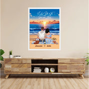 Personalized couple framed canvas of two people sitting together on a beach picnic blanket at sunset, with a custom romantic quote above the ocean and their names written in the sand — LOVECOUPLET