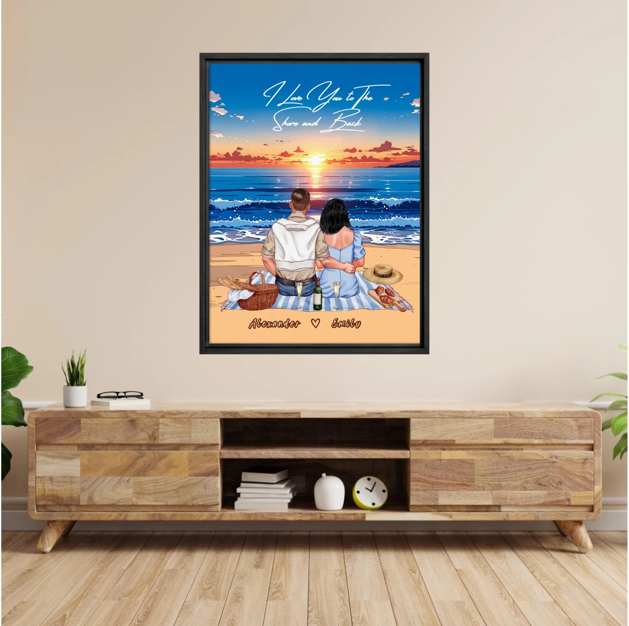 Personalized couple framed canvas of two people sitting together on a beach picnic blanket at sunset, with a custom romantic quote above the ocean and their names written in the sand — LOVECOUPLET