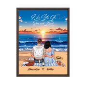 Personalized couple framed canvas of two people sitting together on a beach picnic blanket at sunset, with a custom romantic quote above the ocean and their names written in the sand — LOVECOUPLET