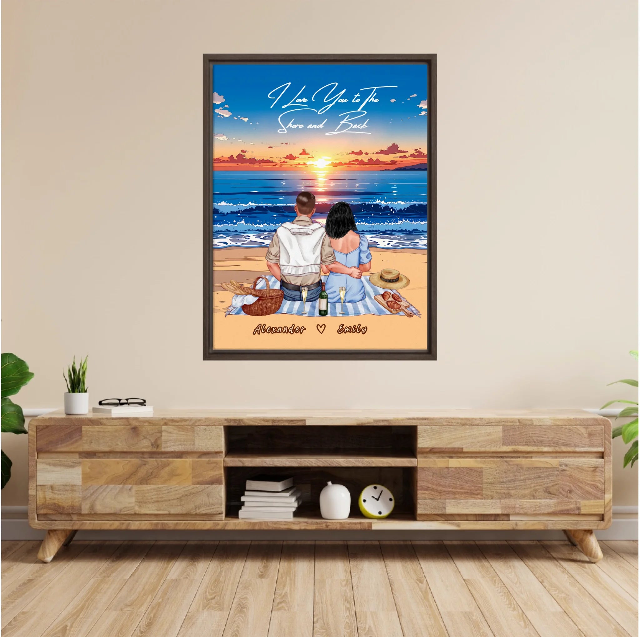 Personalized couple framed canvas of two people sitting together on a beach picnic blanket at sunset, with a custom romantic quote above the ocean and their names written in the sand — LOVECOUPLET